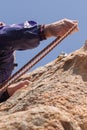 Lead climber extending the rope from his waist to pass it through the quickdraw. Royalty Free Stock Photo
