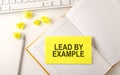 LEAD BY EXAMPLE text on sticker on the diary with keyboard and pencil Royalty Free Stock Photo