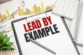 lead by example . text on white paper and pen with charts Royalty Free Stock Photo