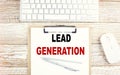 LEAD GENERATION text on a clipboard with keyboard on wooden background