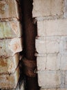 Lead pipe in a cracked brick wall Royalty Free Stock Photo