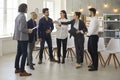 Leader and business team members talking standing in semicircle in office Royalty Free Stock Photo