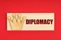 On a red surface there is a wooden block with the inscription - Diplomacy Royalty Free Stock Photo