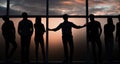 Leader and a group of young people standing near a large window Royalty Free Stock Photo