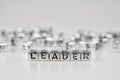 Leader word written on silver cube with black and white bokeh c Royalty Free Stock Photo