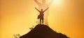 Leadership and achievement people concept. Silhouette of man on mountain top over sunset sky background. Hands up photo