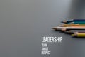 Leadership business concept. Gold color pencil lead other color with word Leadership, team, trust and respect on black background Royalty Free Stock Photo