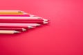 Leadership business concept. red color pencil lead other color on pink background Royalty Free Stock Photo