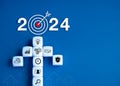 2024 leadership business goal concept. 2024 year number with target icon and white cube block arranged as an arrow shape.