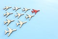 Leadership concept with airplanes on blue wooden background. One red leader flays ahead others. Royalty Free Stock Photo