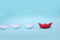 Leadership concept. Blue leader paper ship leading among white on red background Royalty Free Stock Photo