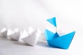 Leadership concept. blue paper ship with flag lead among white. Royalty Free Stock Photo