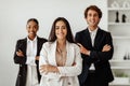 Leadership concept. Businesswoman posing in office interior with her multiracial business team and smiling at camera Royalty Free Stock Photo