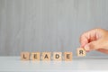 Leadership concept on grey and white background side view. hand picking up wooden cube Royalty Free Stock Photo