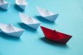 Leadership Concept - Red color paper ship origami leading the rest of the white paper ship on blue cover background Royalty Free Stock Photo