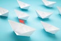 Leadership concept. Red leader paper ship leading among white on blue background Royalty Free Stock Photo