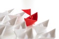 Leadership concept. red paper ship lead among white. One leader