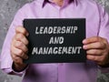 LEADERSHIP AND MANAGEMENT phrase on the piece of paper