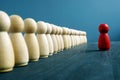 Leadership training concept. Line of figurines and red one opposite