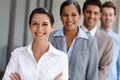 Leading by example. A confident young businesswoman crossing her arms with her team in a line behind her. Royalty Free Stock Photo