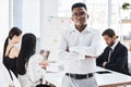 Leading his team to great success. Portrait of a young businessman standing in an office with his colleagues in the Royalty Free Stock Photo