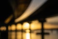 Leading lines from in silhouette underside of twin bridge structure curving through golden glow of sunrise in defocus abstract eff