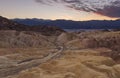 Leading road to eternity at sunset- desert life - mountains in the background in death valley