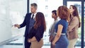 Leading them to success. a group of businesspeople working on a whiteboard in the boardroom.