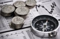 Leading the way to financial success. Studio shot of coins and a compass on the business section of a newspaper.