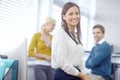 She leads by example. Portrait of an attractive young brunette businesswoman with her colleagues in the background. Royalty Free Stock Photo