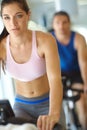 She leads a healthy lifestyle. A man and woman exercising in spinning class at the gym. Royalty Free Stock Photo