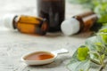 A leaf of ivy and syrup in a bottle on a light concrete table. Production of cough medicine with ivy extract. pharmaceutical indus Royalty Free Stock Photo