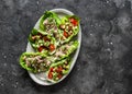 Leaf of mini roman salad stuffed with tuna, egg, tomato, avocado on a dark background, top view. Delicious appetizer, tapas, snack Royalty Free Stock Photo