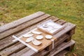Leaf-shaped handmade pottery on old rustic plank table on grass outdoors.