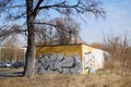 Leafless tree next to a garage building with graffiti in Poznan, Poland