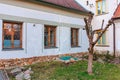 Leafless tree in quaint courtyard with rustic windows and stone accents Royalty Free Stock Photo