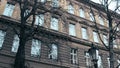 Leafless trees against the classical european building, low angle shot