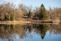 Trees and a fishing pier with relfections in the lake Royalty Free Stock Photo