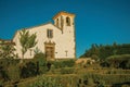 Leafy edge and bushes in a lush flowered garden with old church