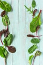 Leafy vegetables, spinach and rukola on a wooden background