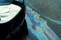 Leakage of oil or gasoline from the car on the asphalt in the parking lot.