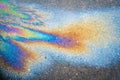 Leakage of oil or gasoline from a car onto a wet asphalt road during snowmelt