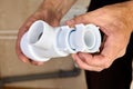 Plumber inspects leaking plastic siphon from sink drain in bathroom. Royalty Free Stock Photo