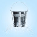 Leaky bucket with water on blue background Royalty Free Stock Photo