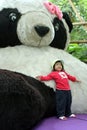 Leaning against giant panda doll