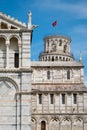 Leaning tower of Pisa peaking from behind Cathedral with brilliant blue sky Royalty Free Stock Photo