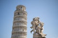 Leaning Tower of Pisa with statue angel at sunny day