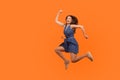 Leap to success. Full length of excited energetic motivated brunette woman in denim dress running in air