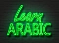 Learn Arabic, neon sign on brick wall