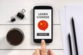 Learn Chinese concept on smart phone screen with office objects Royalty Free Stock Photo